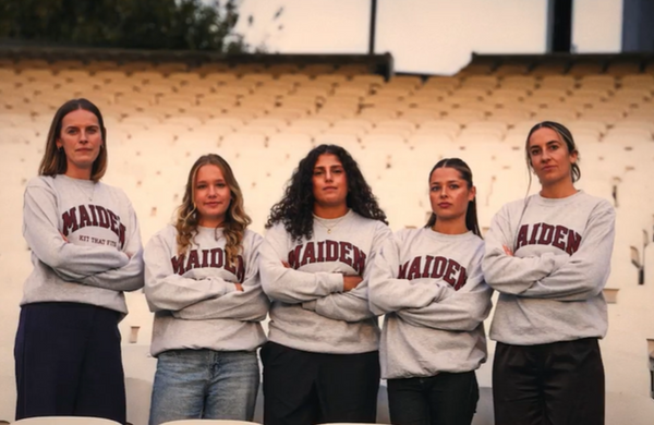 Five members of the Maiden Cricket Player Advisory Board in grey Maiden sweatshirts, arms crossed, standing in a stadium stand