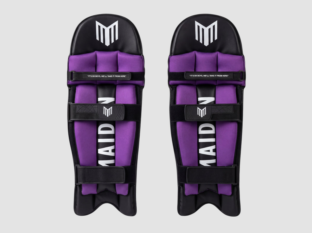 Maiden Cricket girls' batting pads in black and purple with ergonomic knee curve and secure soft-touch straps.