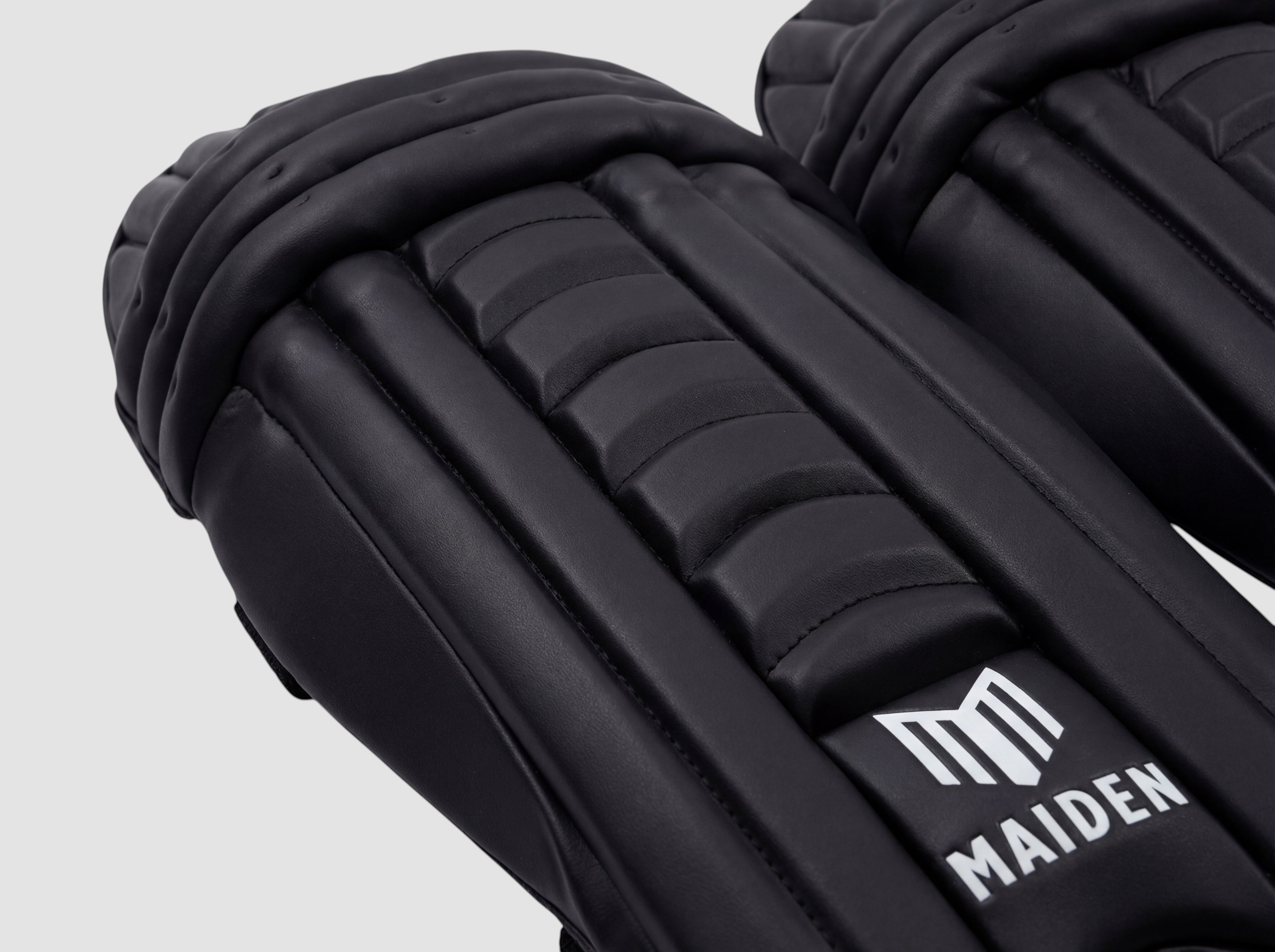 Maiden Cricket girls' black batting pads with ergonomic knee curve and lightweight high-impact protective armour