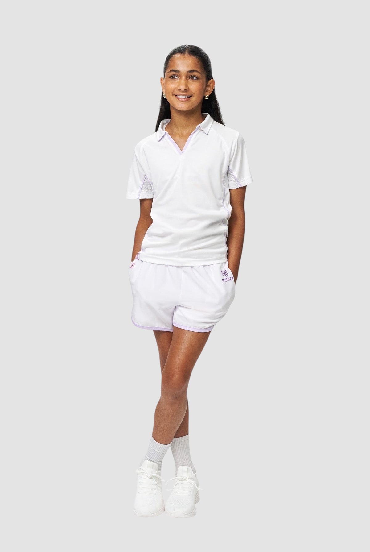 Maiden Cricket girls wearing white athletic shorts with purple trim, built-in undershorts, and a matching polo shirt.