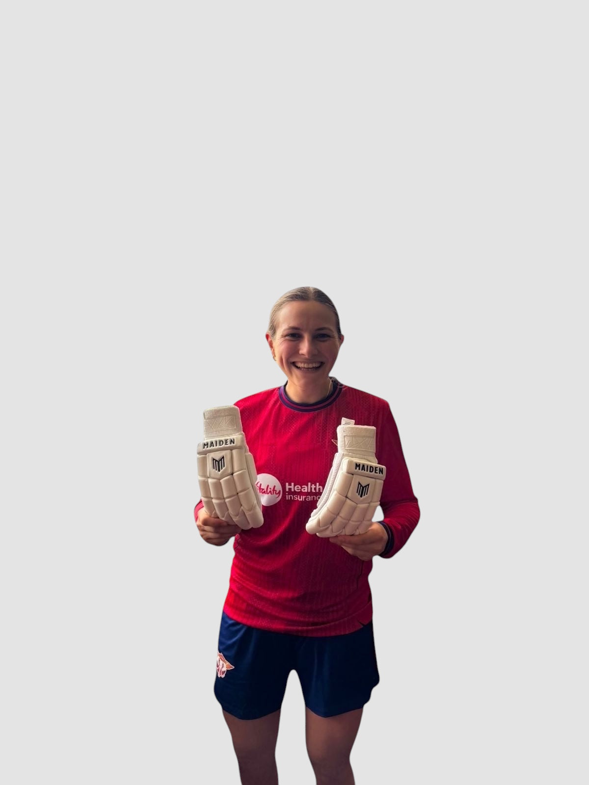 Maiden Cricket Mia Rogers limited edition white batting gloves held by a female cricketer in a red jersey