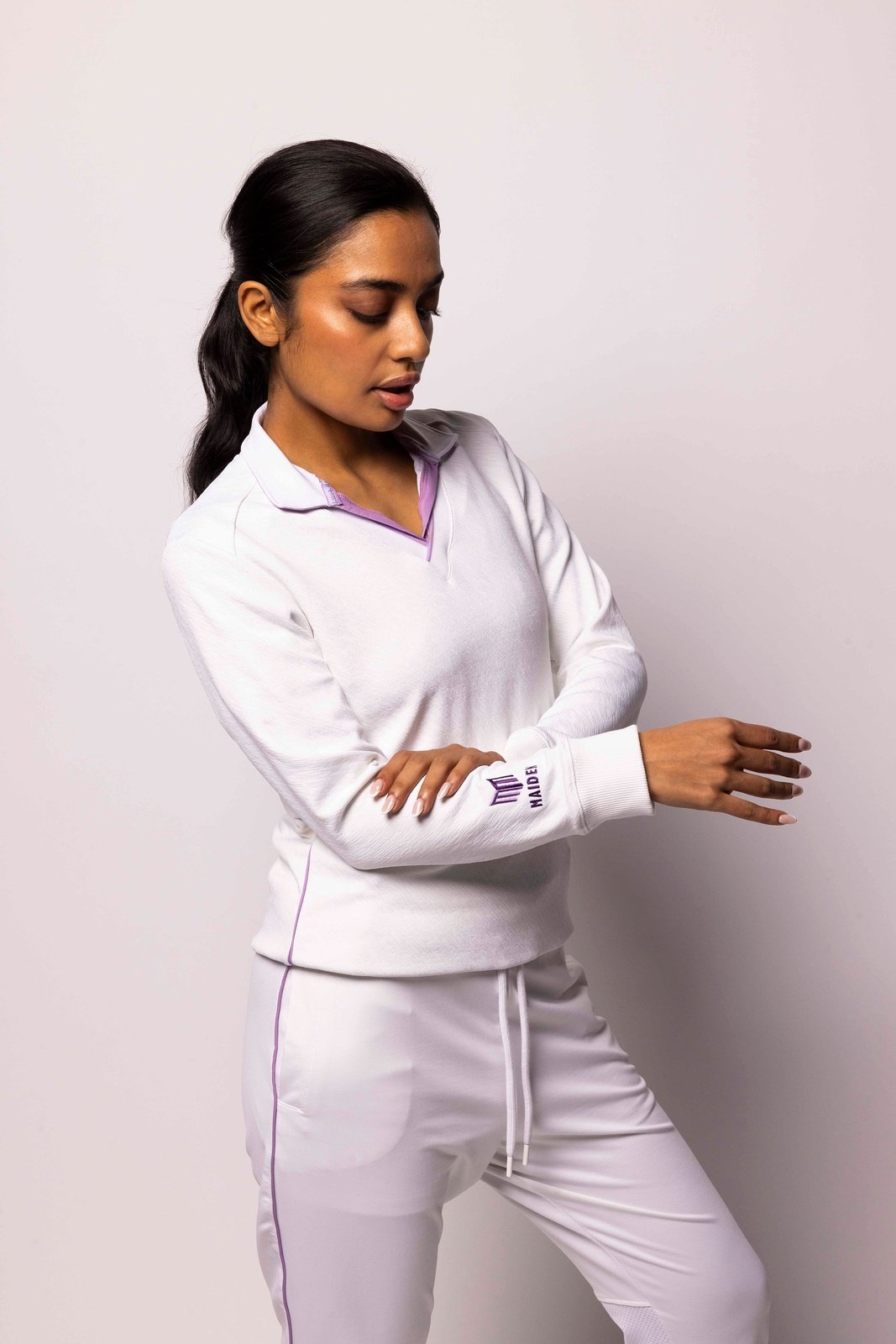 Woman wearing a Maiden cricket pullover, perfect for on-field performance and comfort.