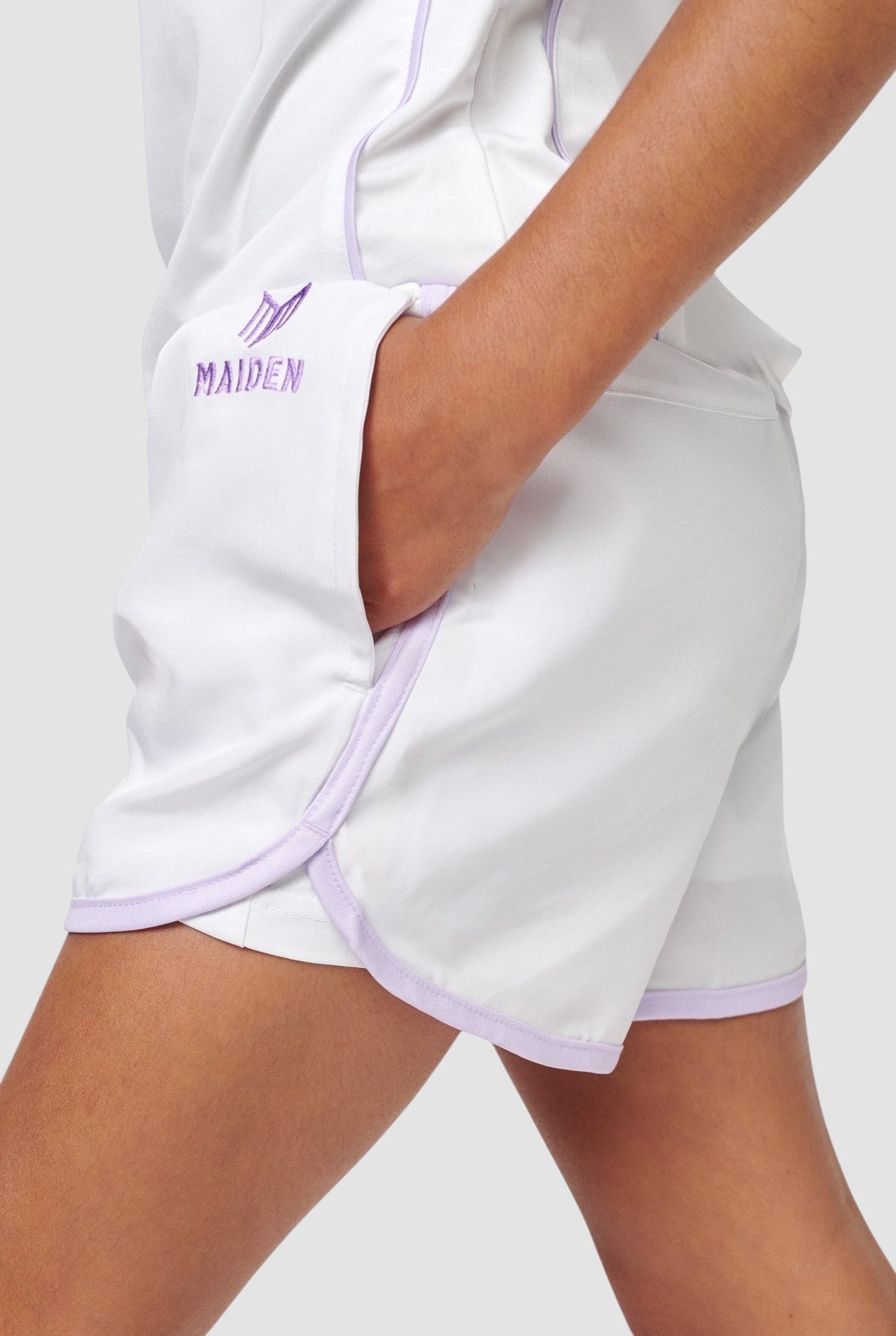 Maiden Cricket white girls sports shorts with purple trim, curved hem, and built-in undershorts for active movement.