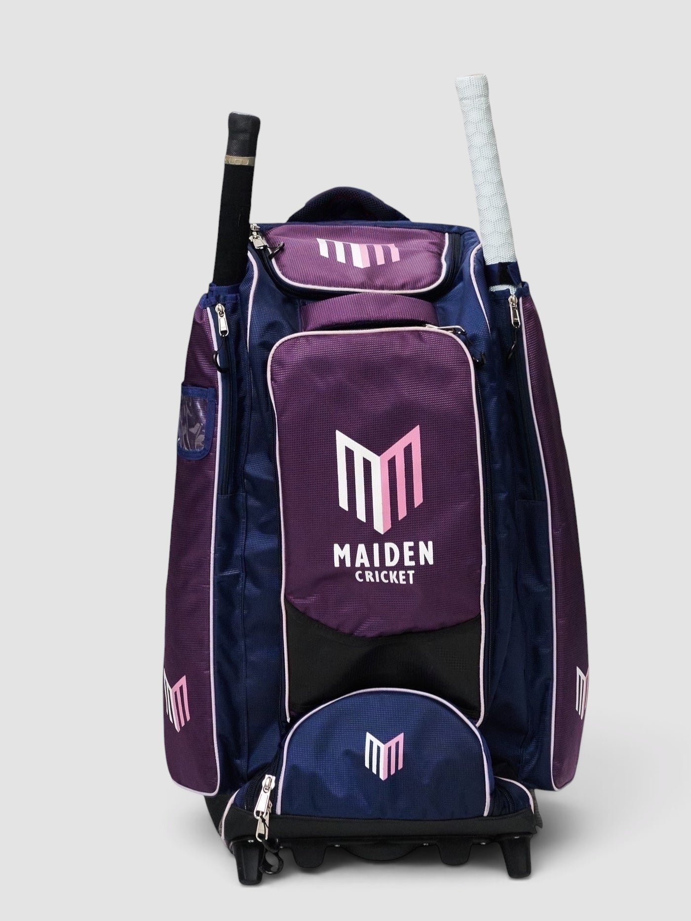 Maiden Cricket kit bag in navy and purple with pink logo, featuring external bat storage and wheeled base.