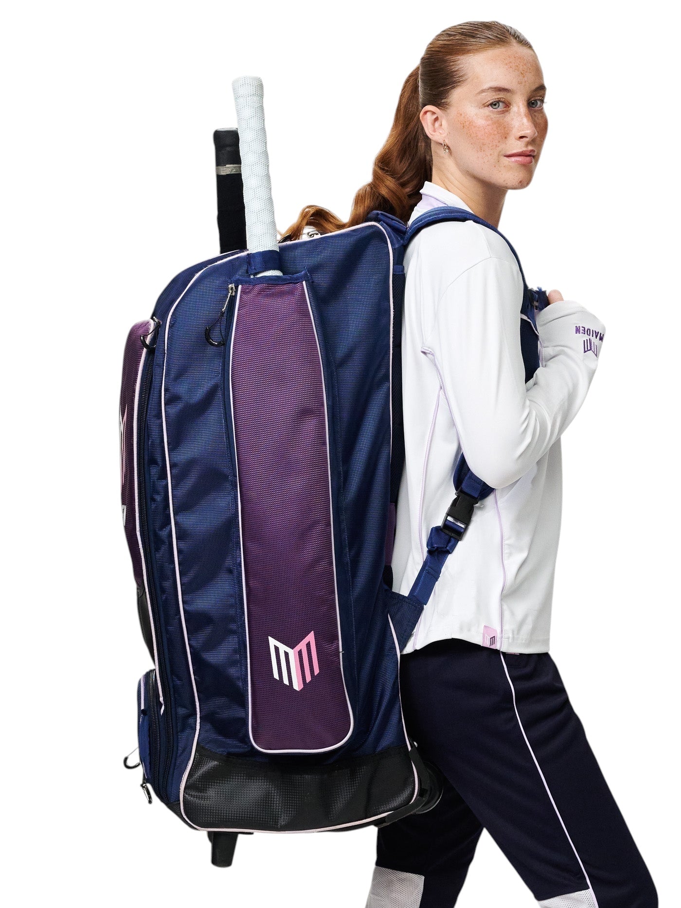 Female cricketer wearing a navy and purple Maiden Cricket kit bag with ergonomic straps and a cricket bat