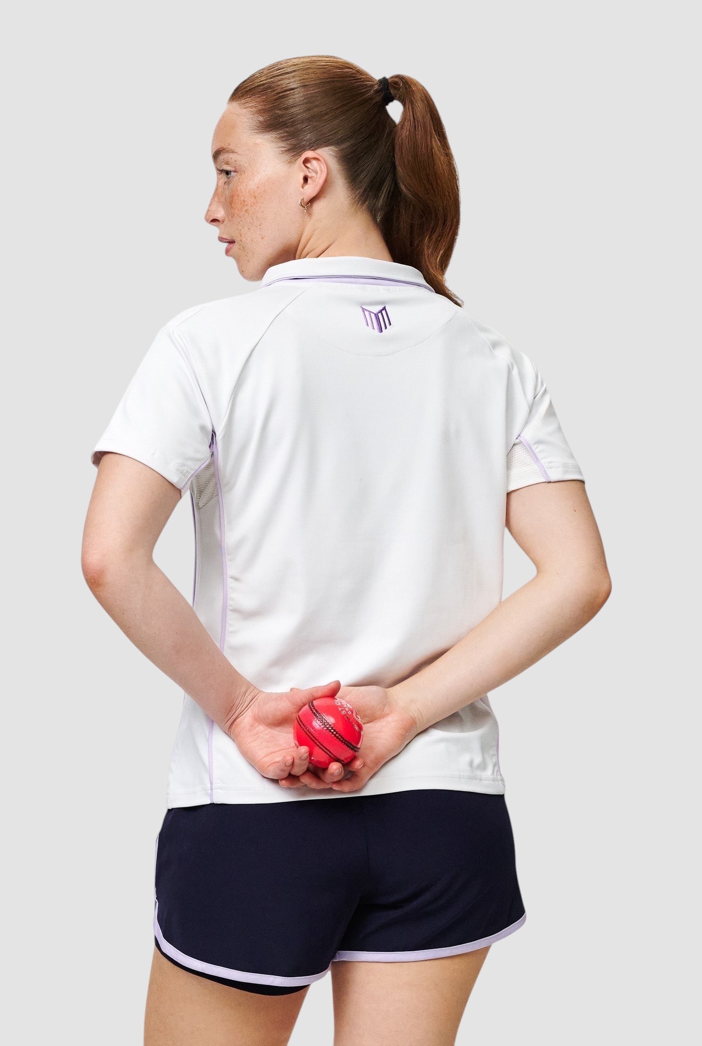 Maiden Cricket women's white performance V-neck cricket top with mesh underarm panels, worn by a female player