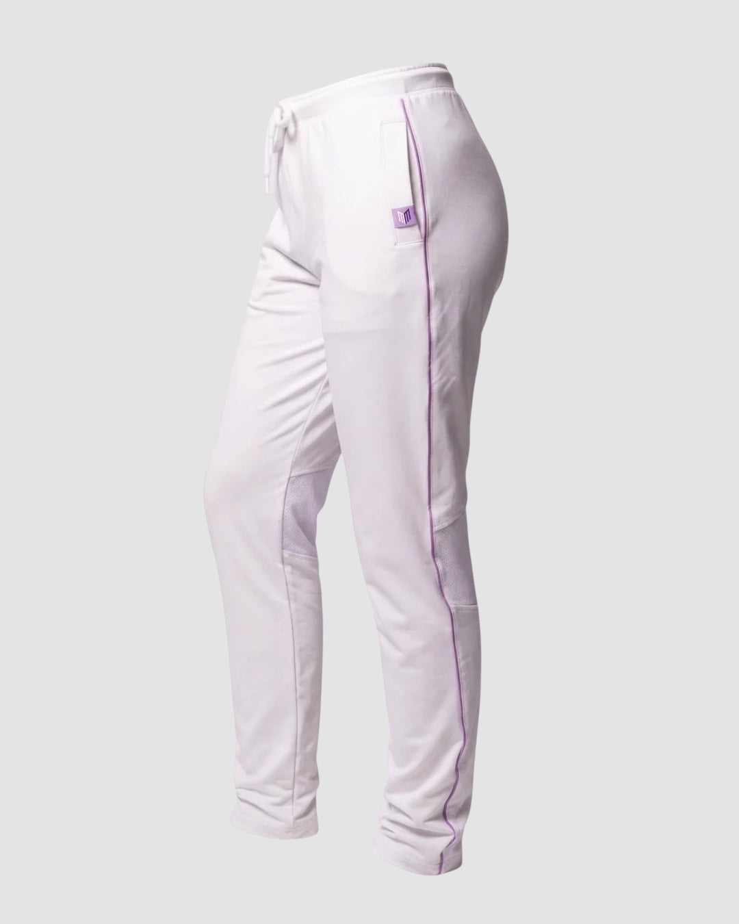 Maiden Cricket women's white cricket trousers with purple piping, mesh knee vents, and side pockets on a grey background