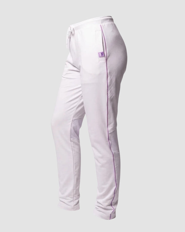 Maiden Cricket women's white cricket trousers with purple piping, mesh knee vents, and side pockets on a grey background