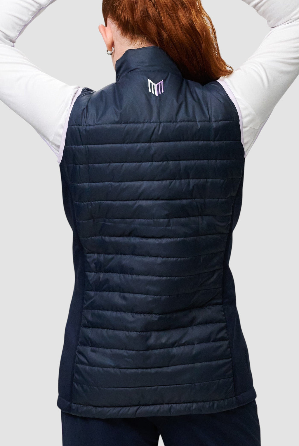 Back view of a girl wearing a navy Maiden Cricket Yorker Gilet with stretch side panels and a small logo on the neck