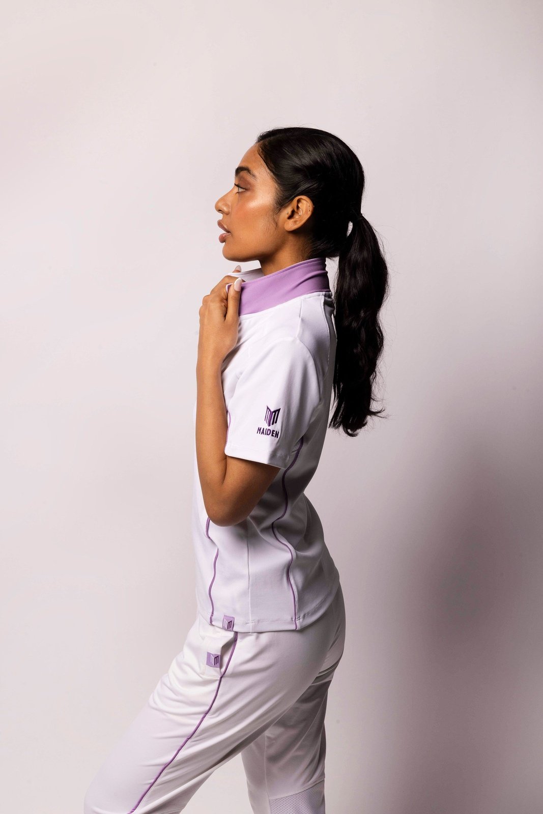  Woman wearing a Maiden top, designed for style and comfort in cricket.